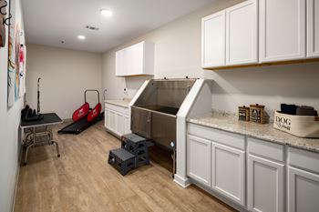 A kitchen with white cabinets and a wooden floor.